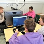 4 uczniów siedzi przy komputerach