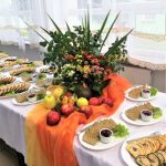 stół z potrawami i dekoracją z kwiatów