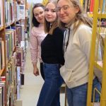 3 kobiety między regałami z książkami
