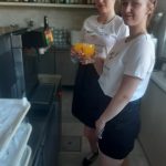 Dwie uczennice stoją przy automacie z napojami