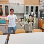 uczeń pod rękę z plastikowym szkieletem