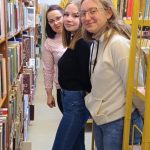 Trzy kobiety między regałami z książkami