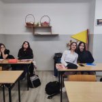 Cztery uczennice siedzą w klasie w ostatnich ławkach