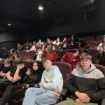 uczniowi siedzą w kinie