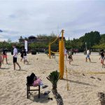 Grupa osób gra w siatkówkę na plaży