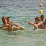 Grupa osób pływa w morzu