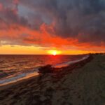 Malowniczy zachód słońca nad brzegiem plaży.