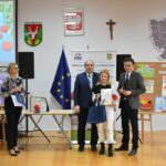 Wręczenie laureatce konkursu nagrody przez komisję.